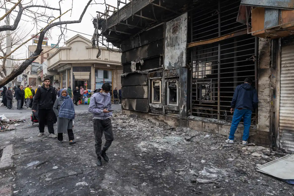 Pedestrians passing a burned building in Tehran after the protests
